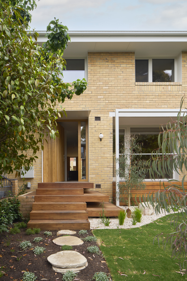 Front entry of a Fitzroy home showing brick façade, timber steps and landscaped garden completed by HONE.