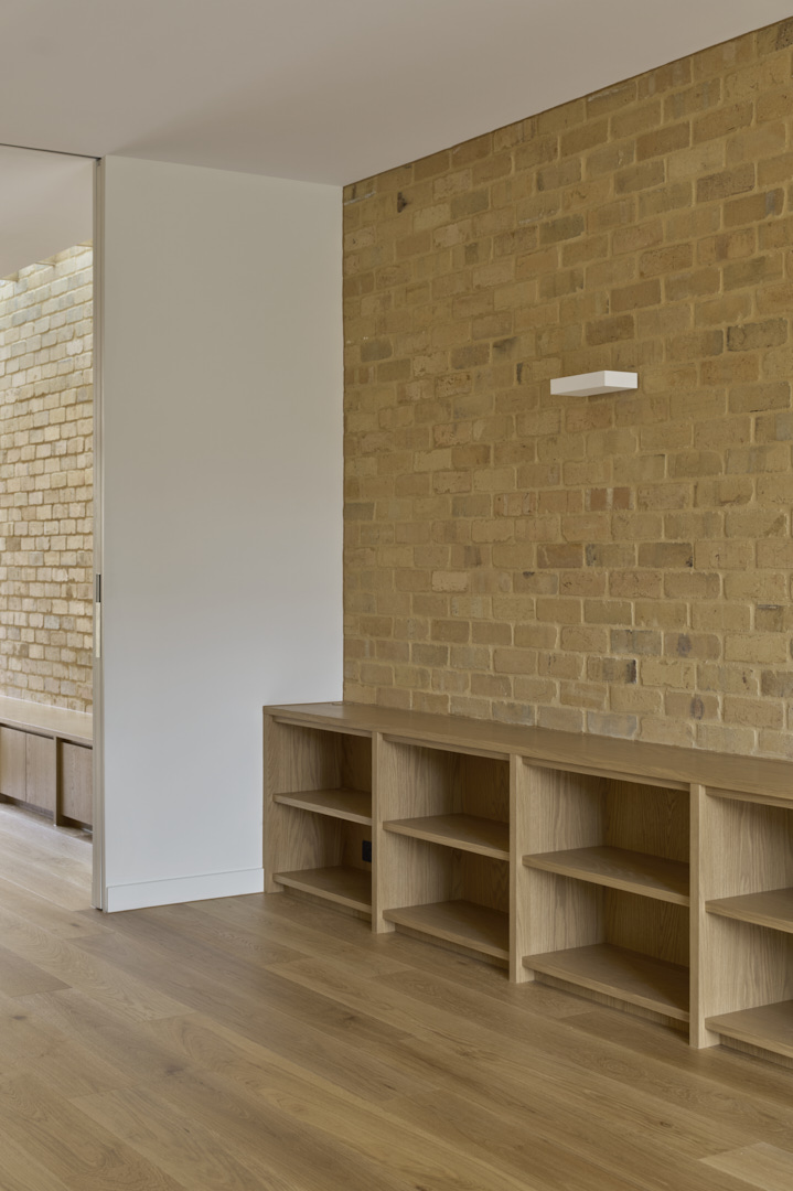 Custom timber joinery and exposed brick wall inside a Fitzroy home, highlighting careful detailing and material continuity.